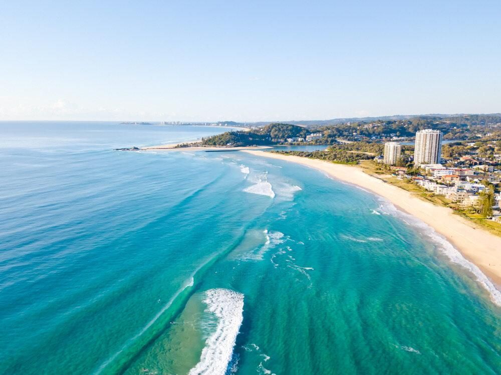 An Aerial View of a Beach With Waves Crashing on the Shore — Abbsolve Services in Palmview, QLD