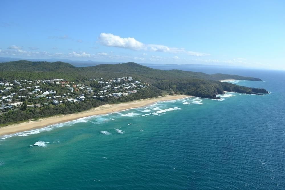 An Aerial View of a Beach Surrounded by Mountains and a Body of Water — Abbsolve Services in Peregian Beach, QLD