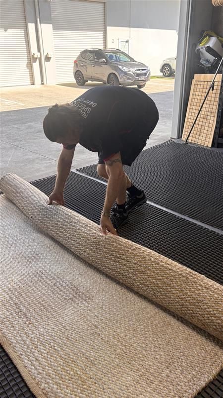 A Woman is Cleaning a Couch With a Vacuum Cleaner in a Living Room — Abbsolve Services in Cooroy, QLD