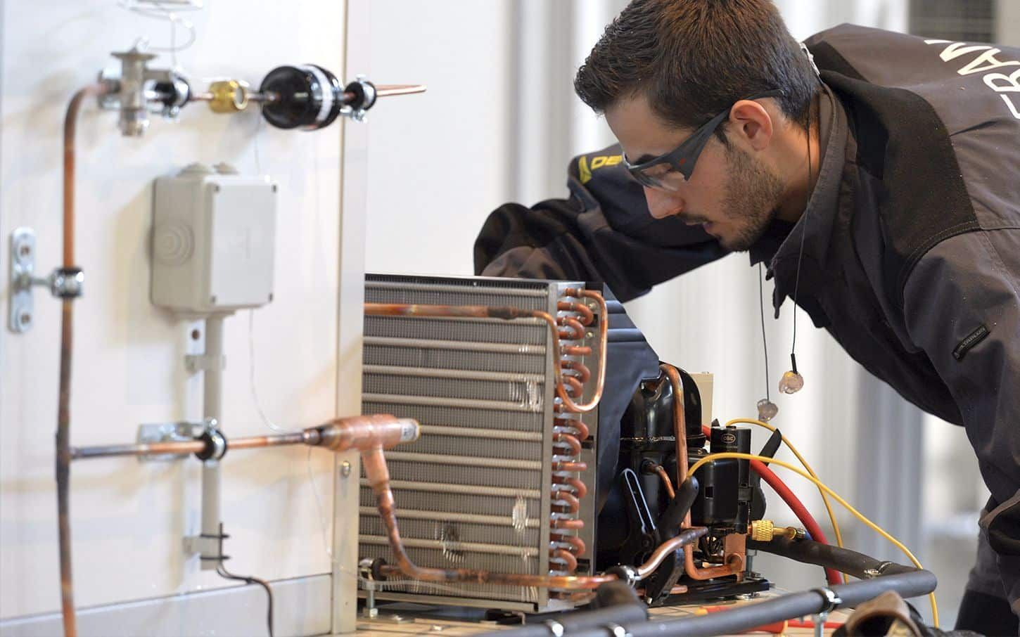 Un homme travaille sur une machine avec une perceuse.