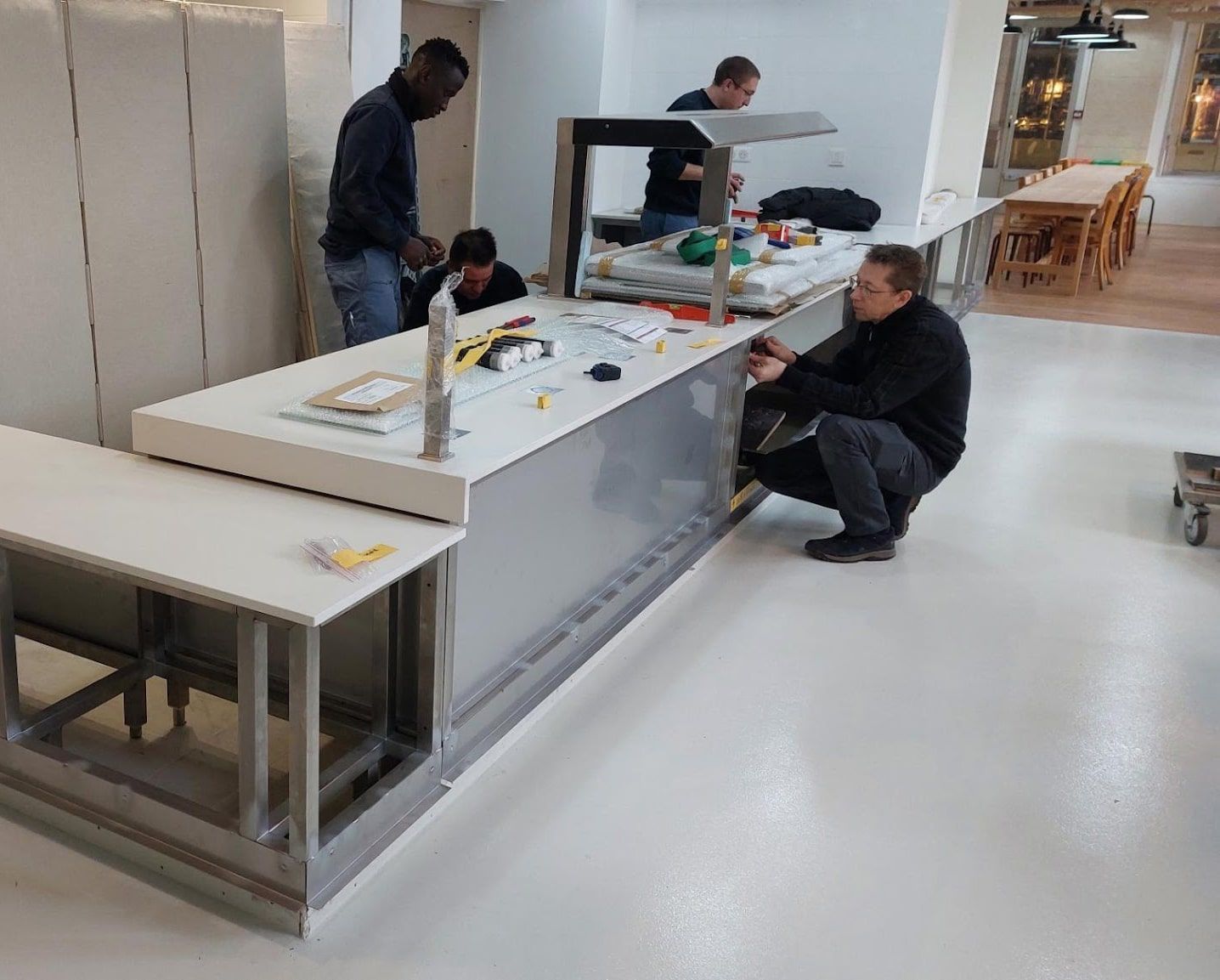 Un groupe d'hommes travaille sur un comptoir dans une cuisine.