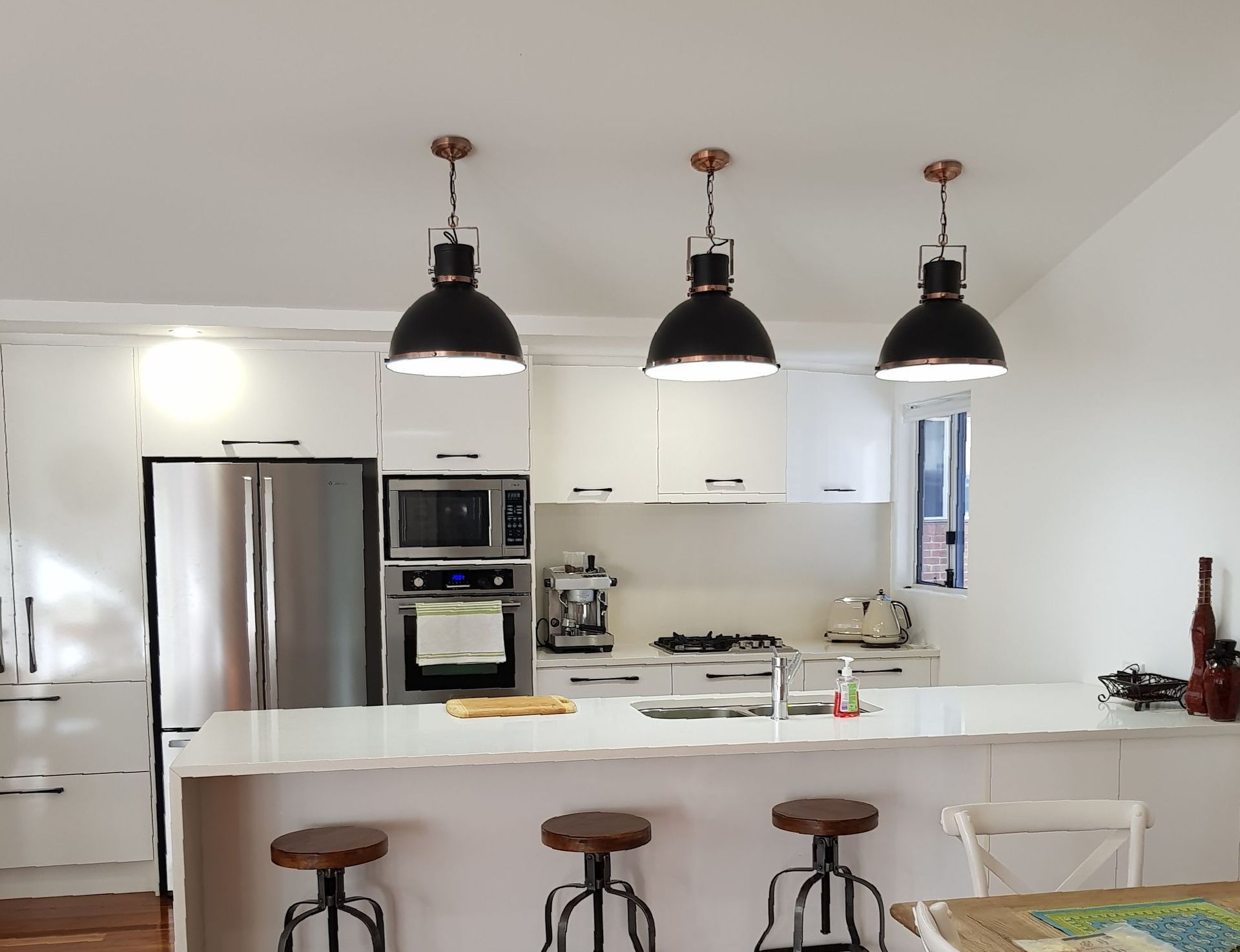 Black Round Industrial Pendant Lighting In White Kitchen — Forster Solar & Lighting In Nabiac, NSW