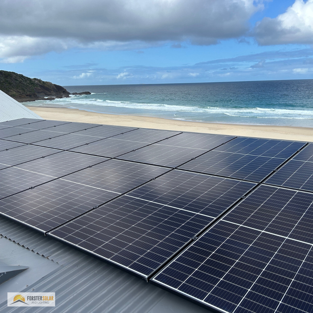A Row of Solar Panels on A Roof with A Beach in The Background — Solar Electricians in Forster, NSW