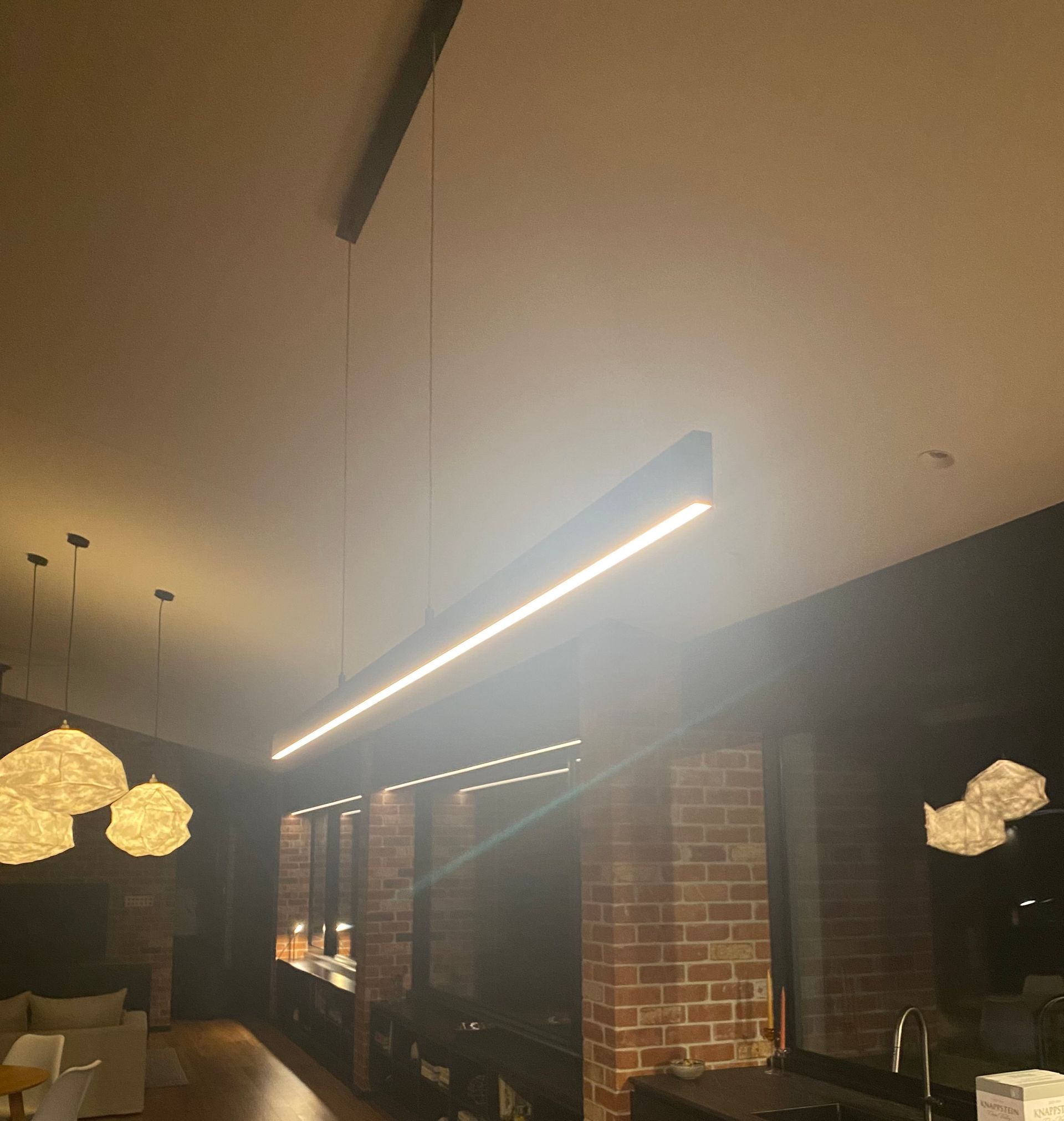 A Kitchen with White Cabinets , a Table , Chairs and A Refrigerator — Solar Electricians in Forster, NSW