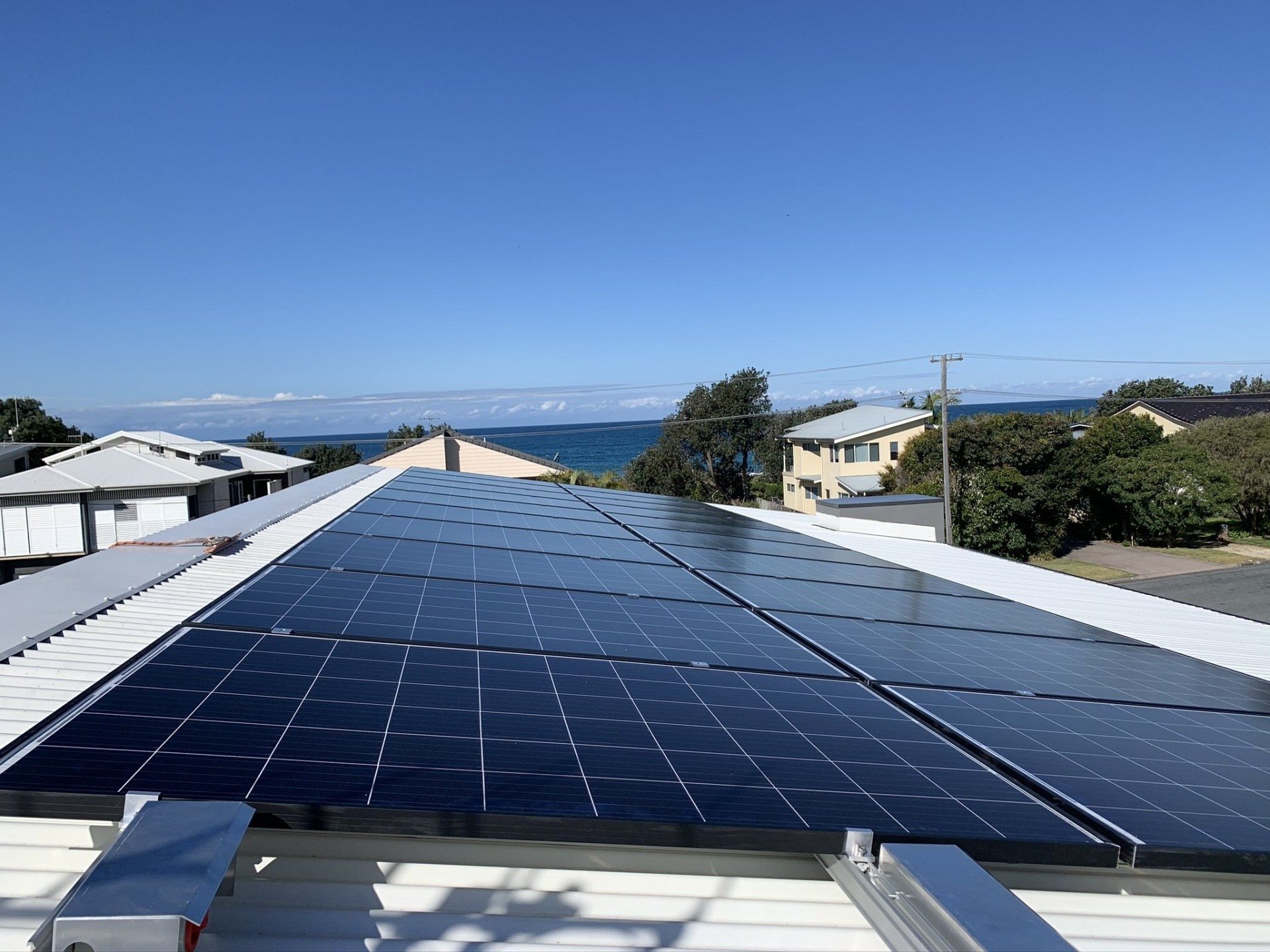 Solar Panel On A Red Roof Reflecting The Sun — Solar Electricians in Forster, NSW