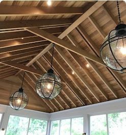 Wooden ceiling with globe pendant lights, beneath a windowed room.