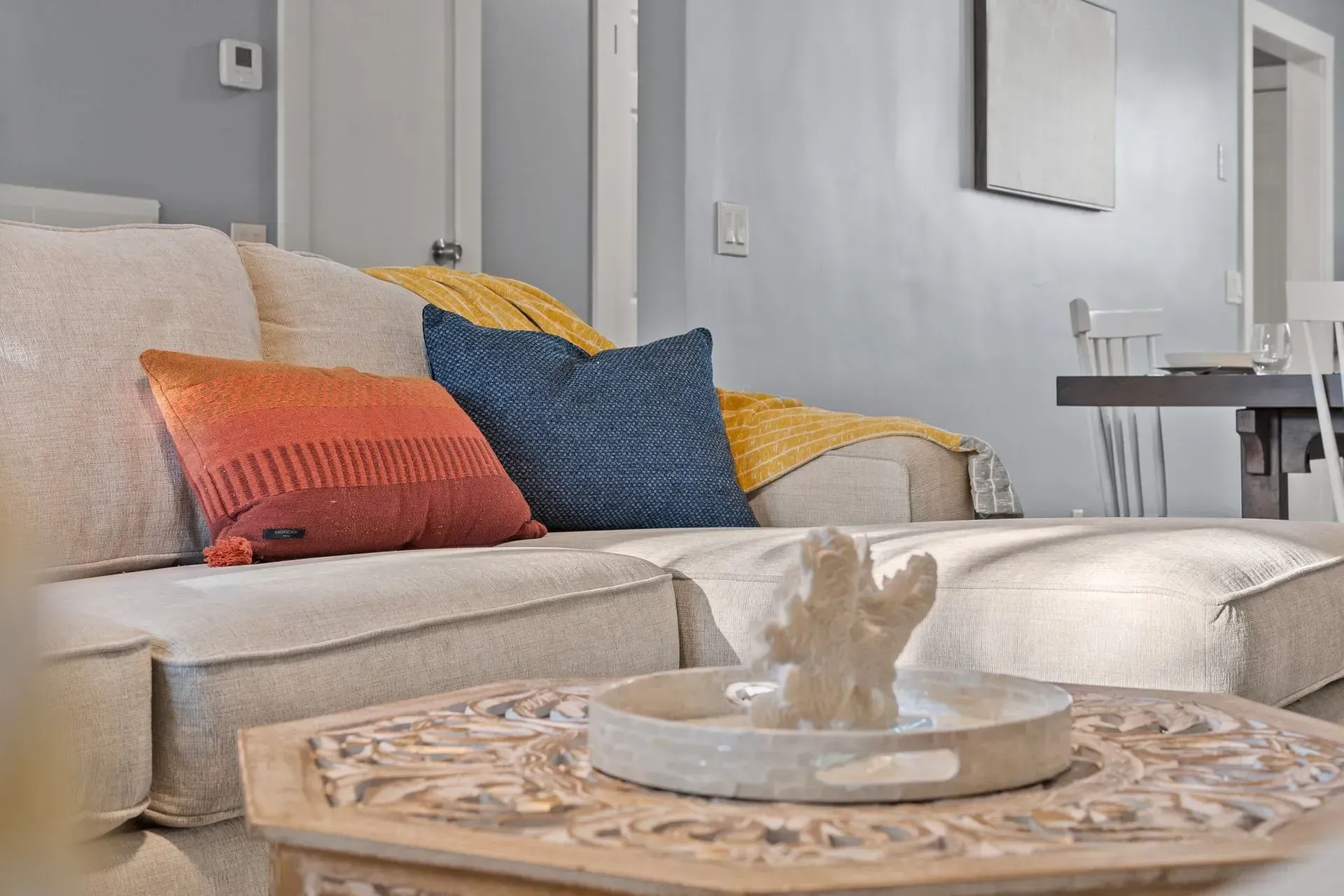 Palm tree on a white sandy beach with turquoise water under a blue sky.