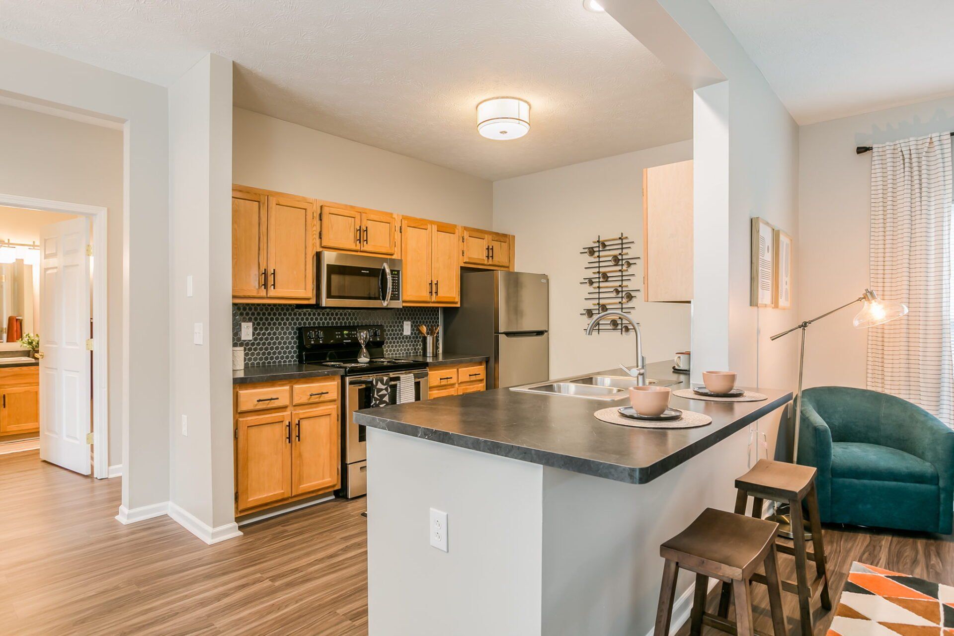 Kitchen with stainless steel appliances, modern backsplash, and breakfast bar