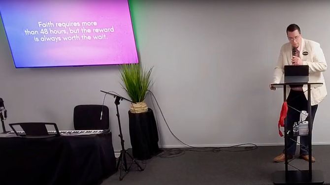 A man is standing at a podium talking into a microphone.