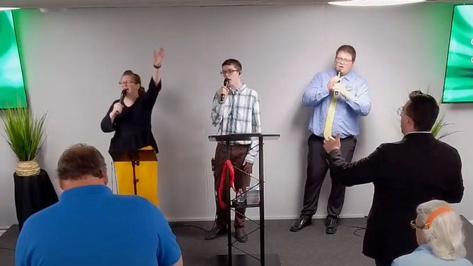 A group of people are singing into microphones in a church.