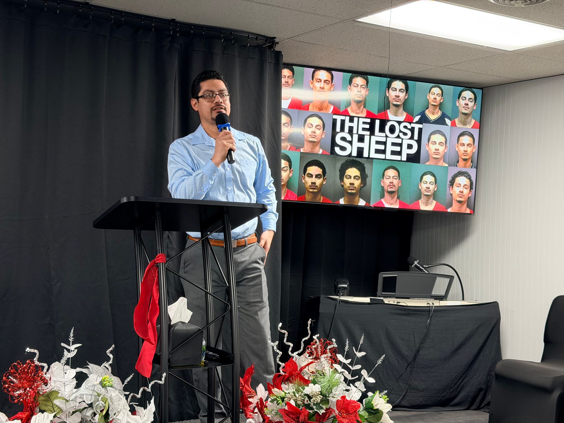 A group of people are sitting under a tent talking to each other.
