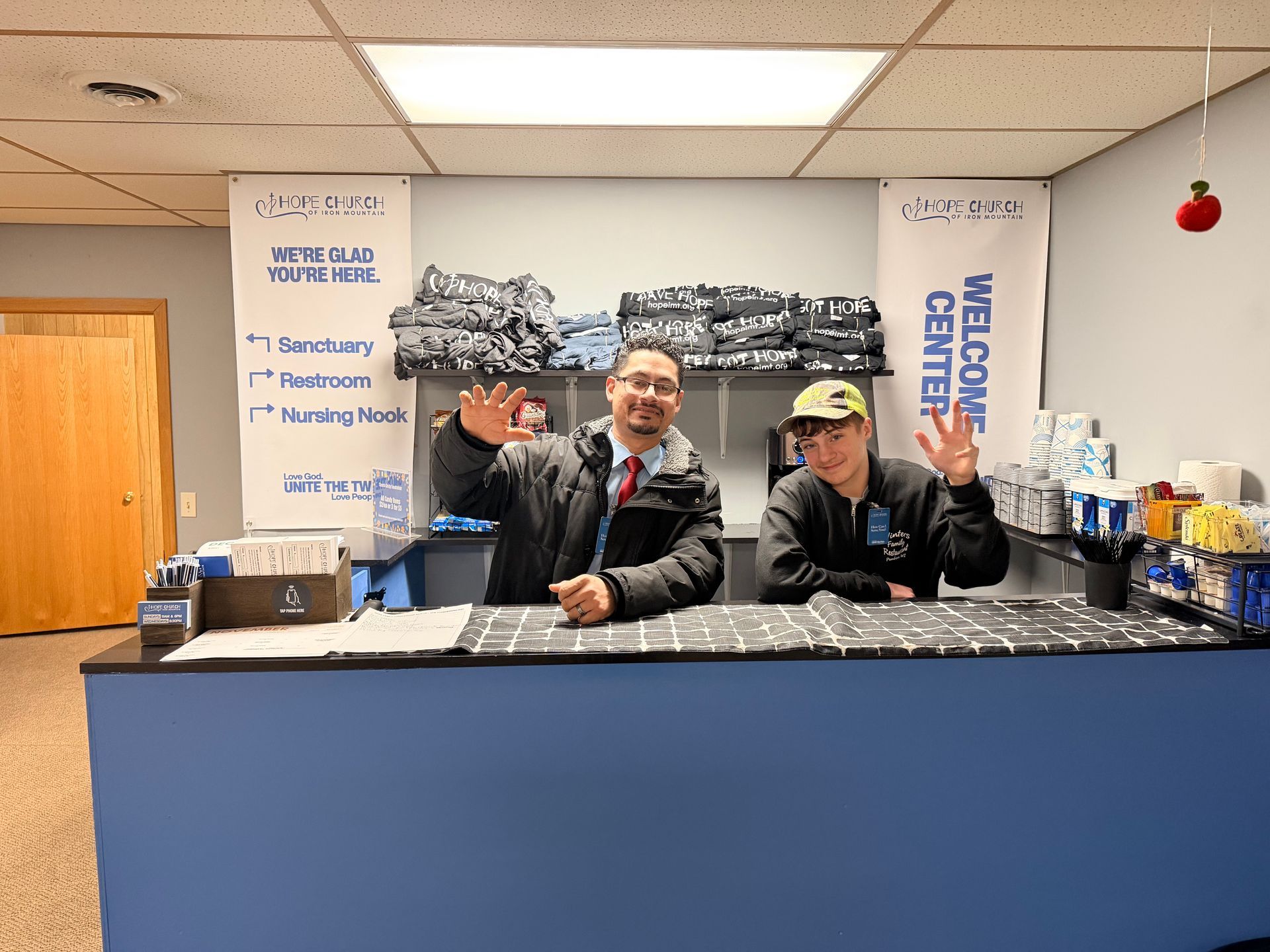 A little girl wearing a black shirt that says jesus is coming is giving a peace sign.