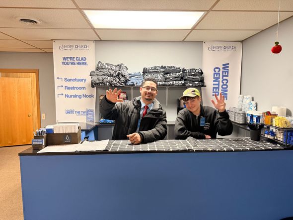 A little girl wearing a black shirt that says jesus is coming is giving a peace sign.