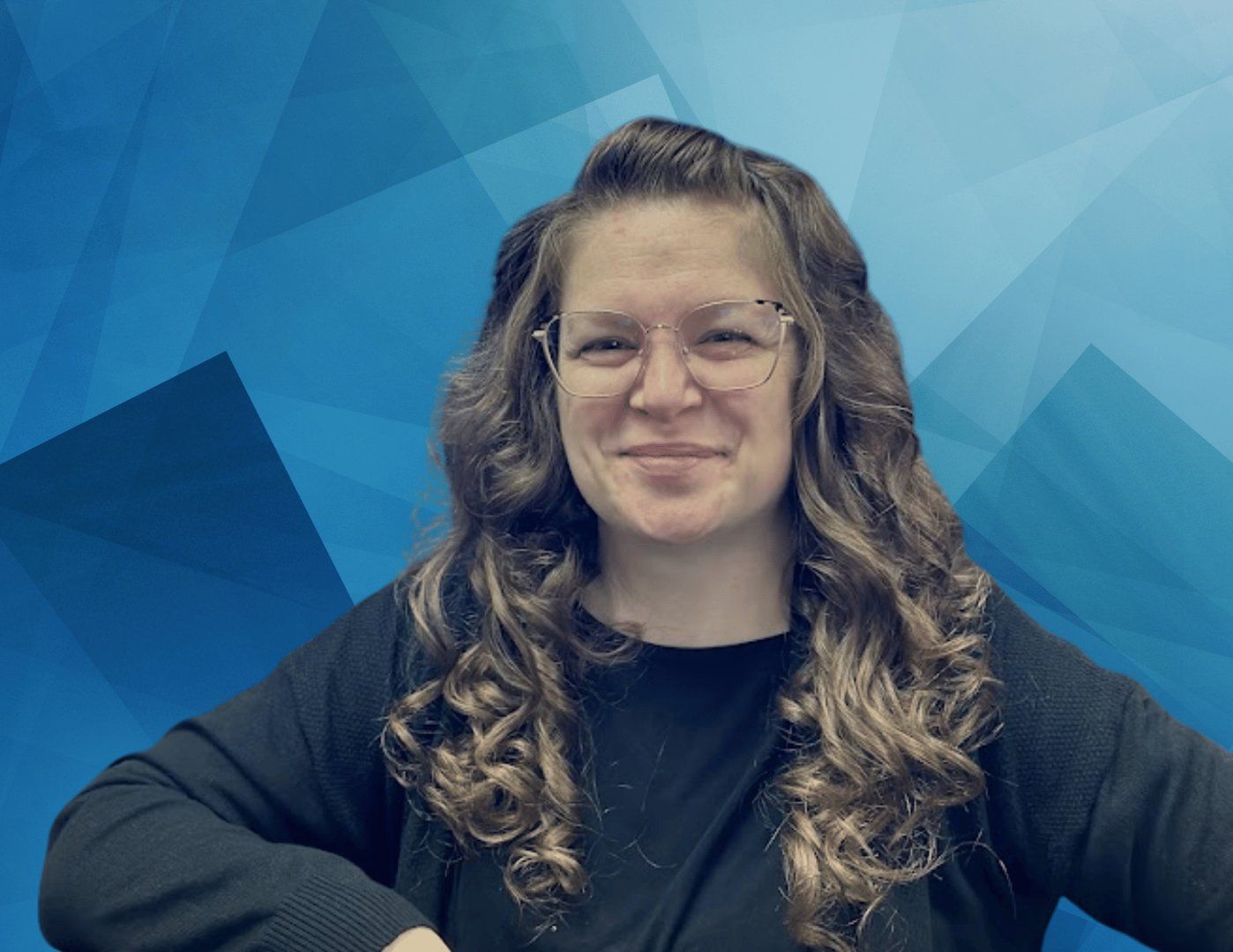 A woman wearing glasses and a black shirt is smiling in front of a blue background.