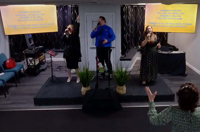 A group of people are singing into microphones in a church.