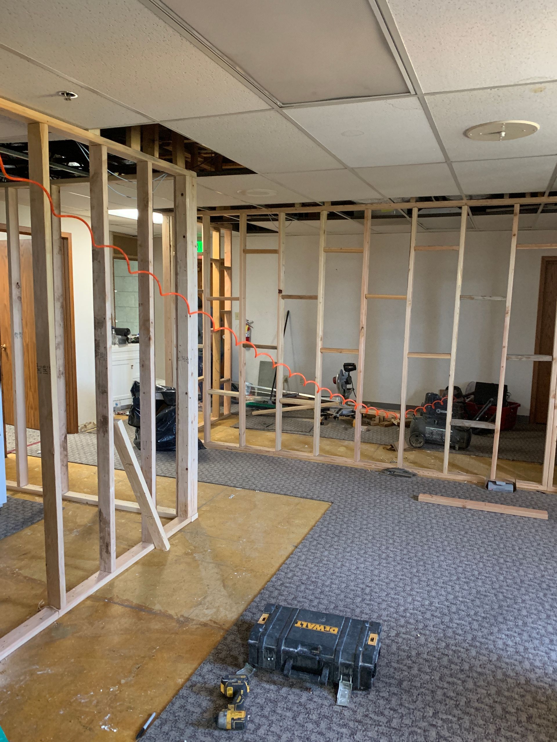 A dewalt toolbox sits on the floor in a room under construction