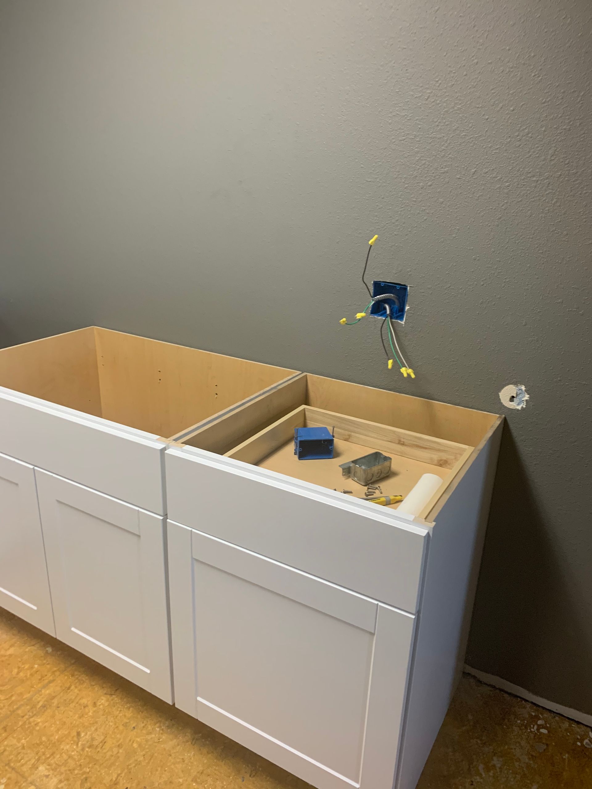 Two white cabinets are sitting next to each other in a room.