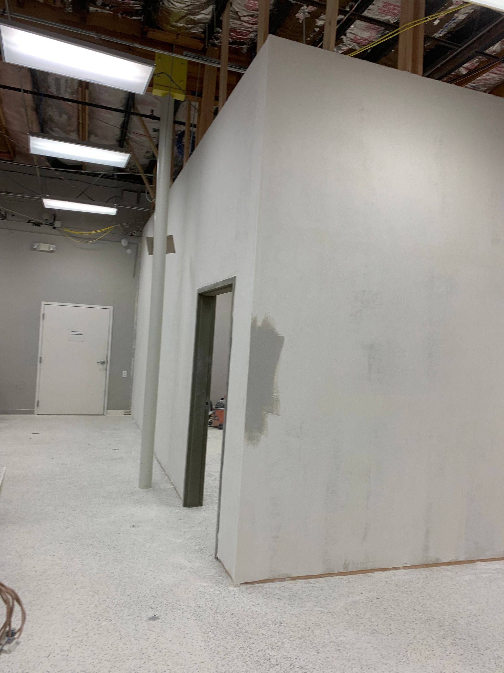 A room with a lot of white walls and a door