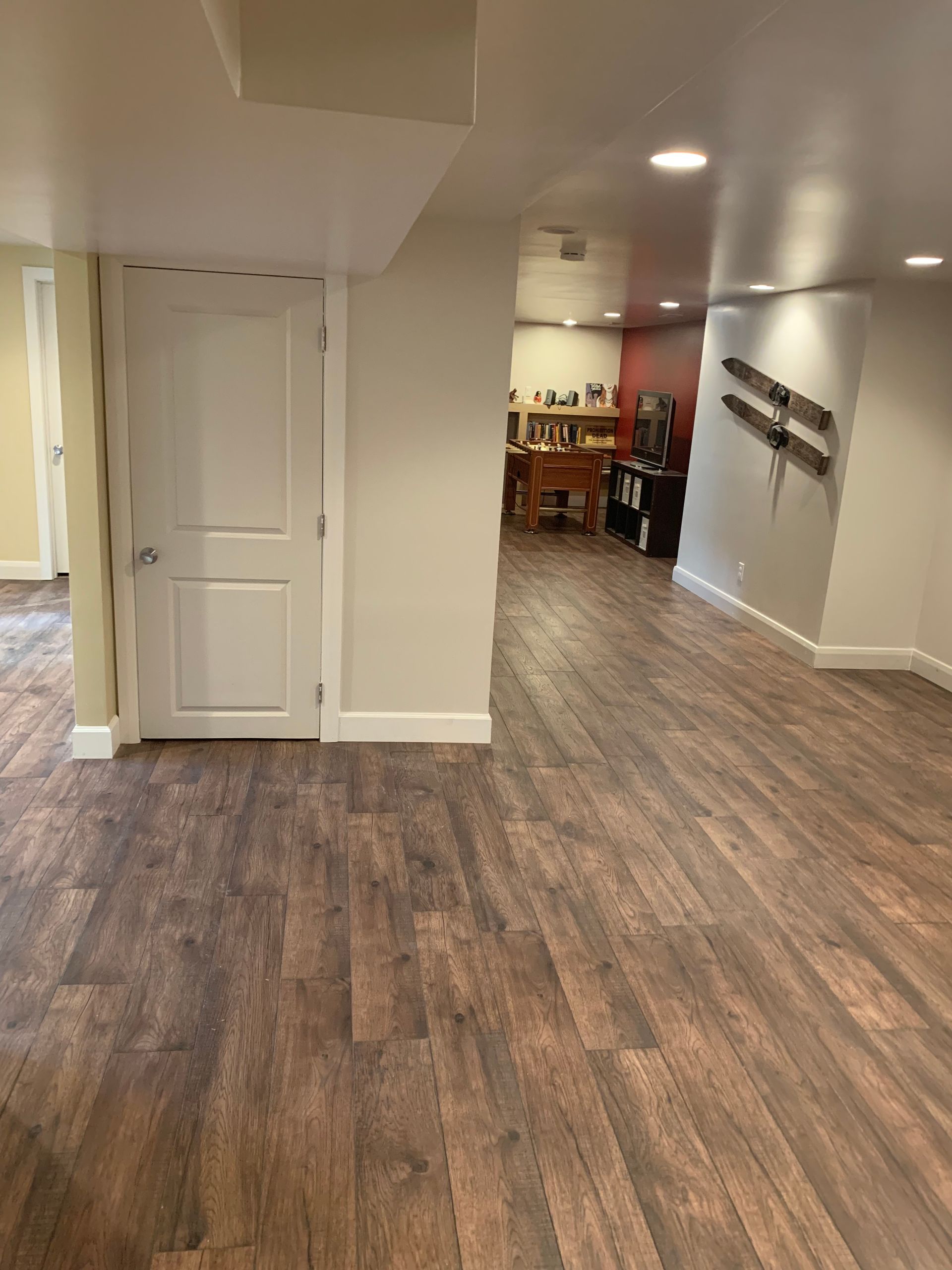 A basement with wooden floors and white walls.