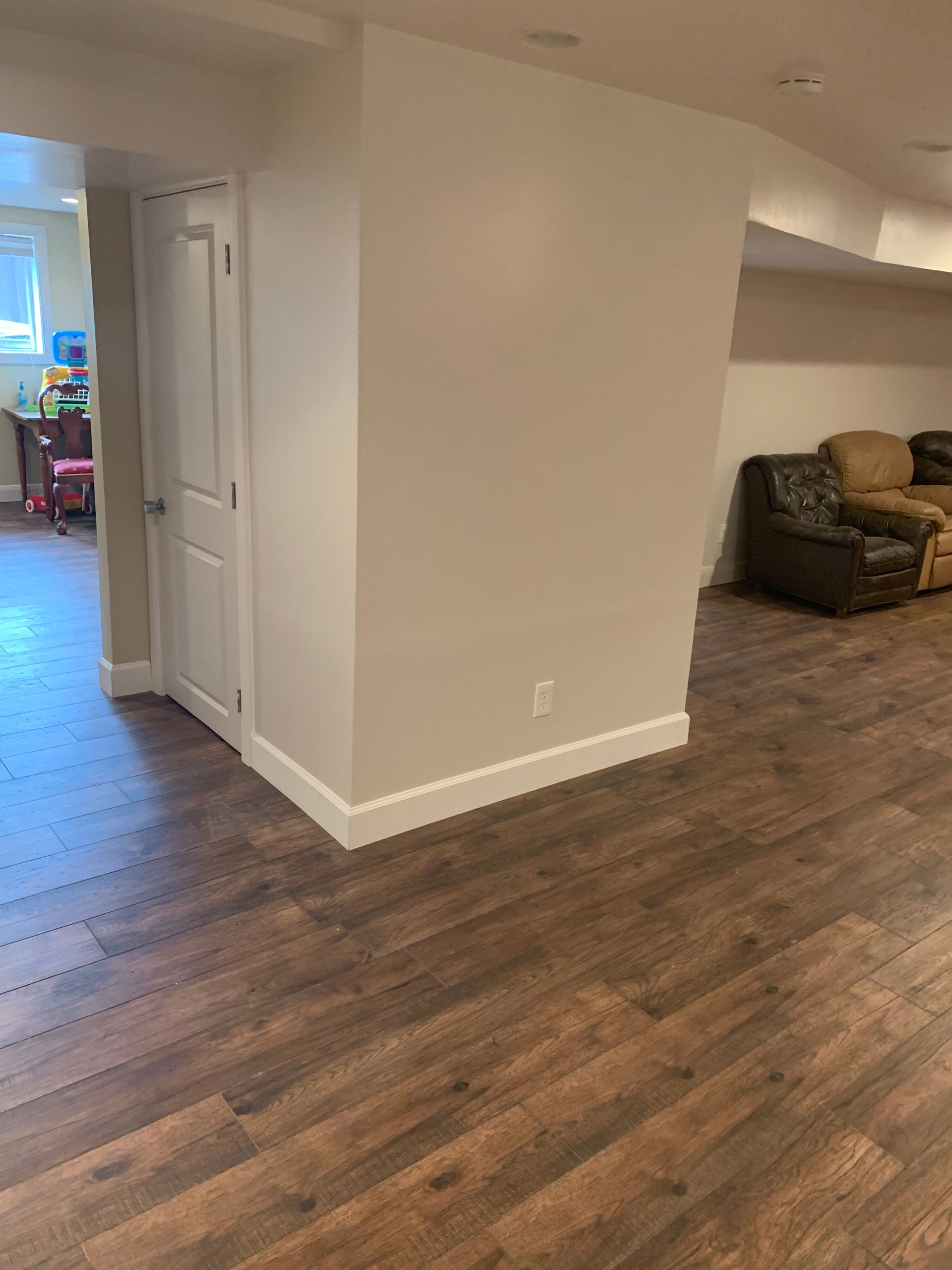 A basement with hardwood floors and white walls.