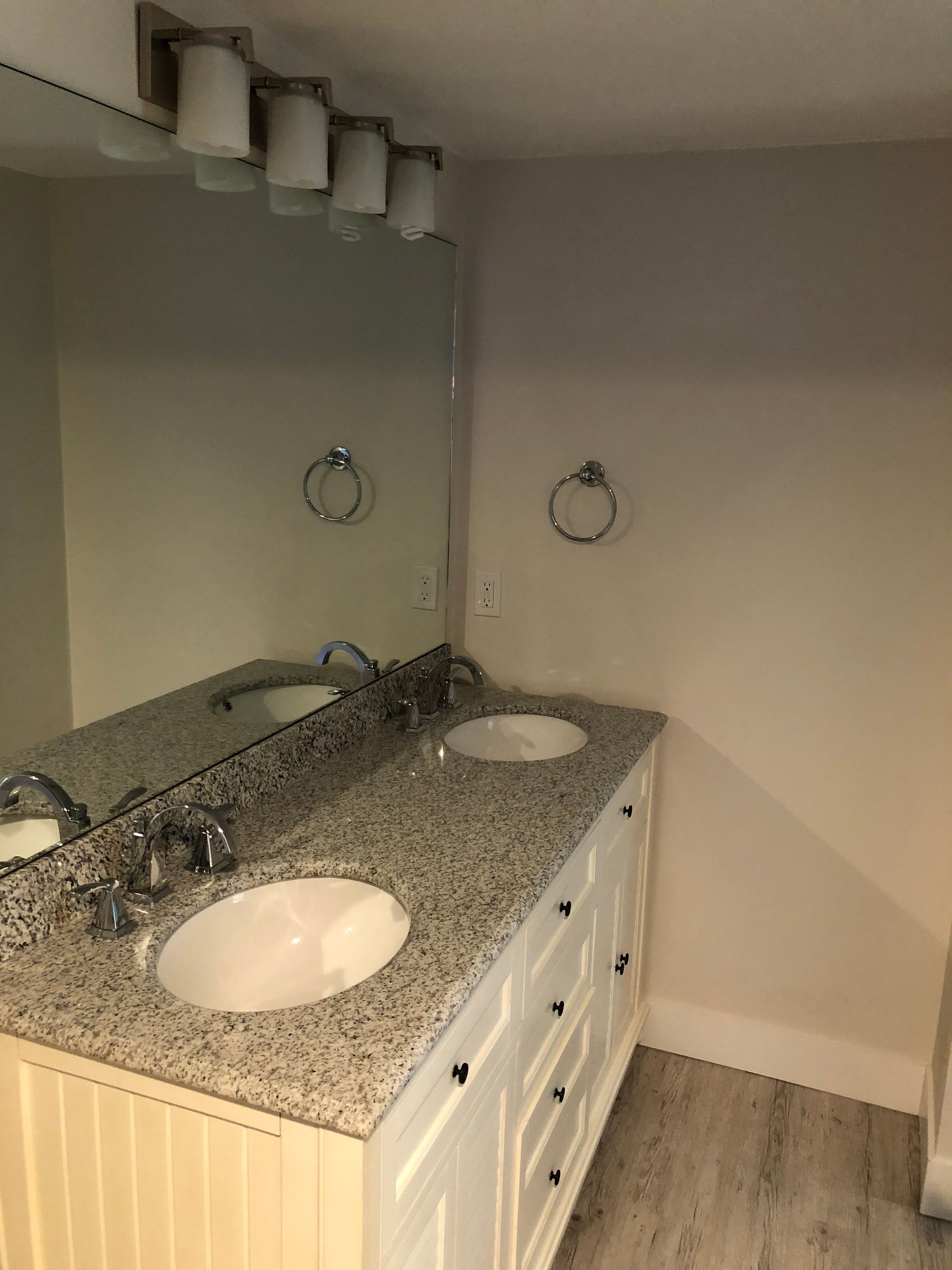 A bathroom with two sinks and a large mirror.