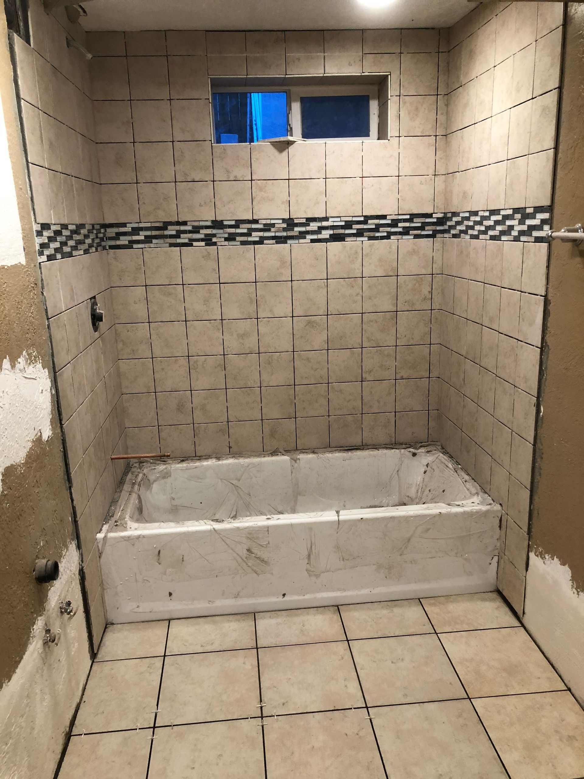 A bathroom with a bathtub and a window.