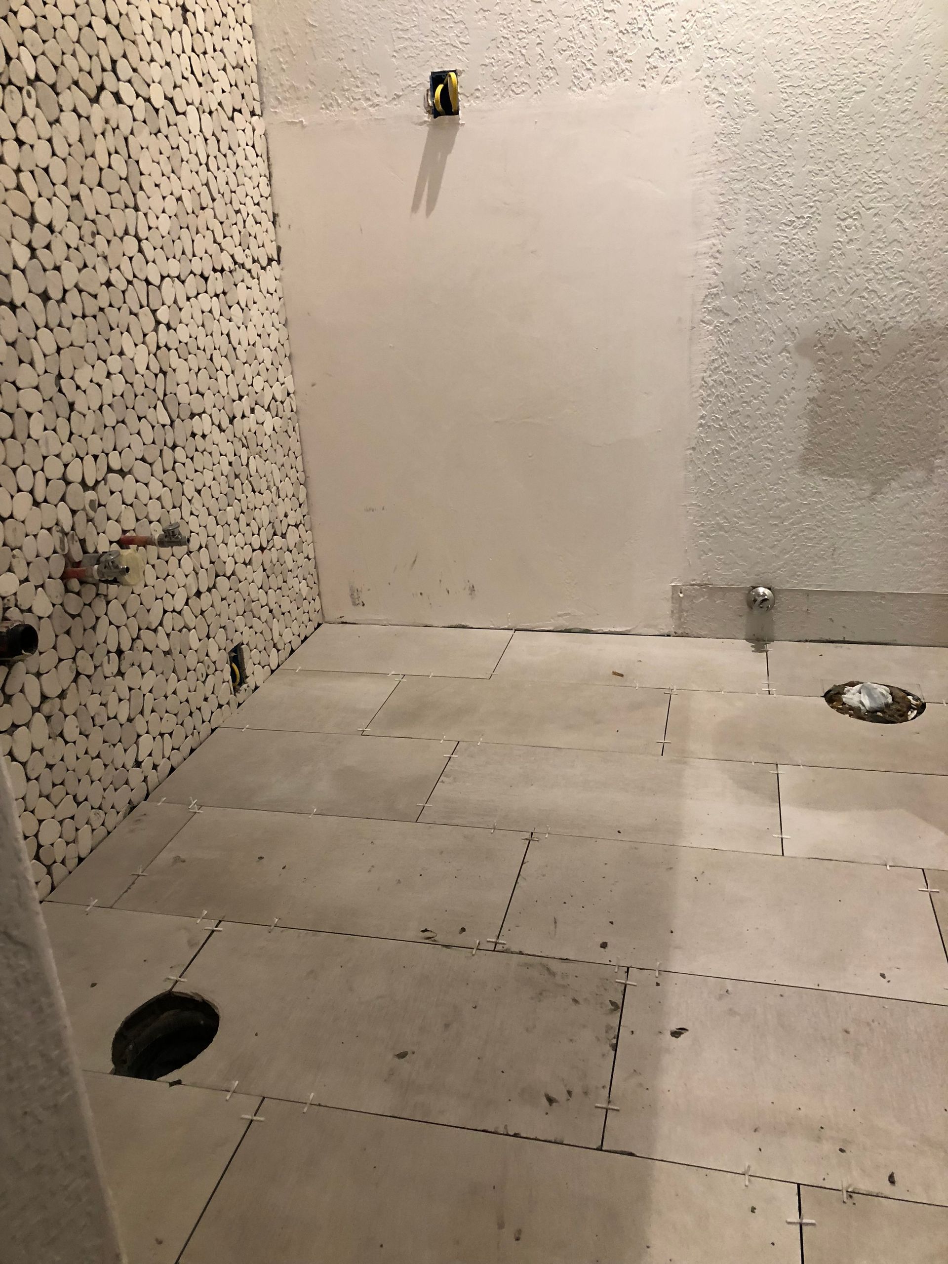 A bathroom under construction with a hole in the floor.