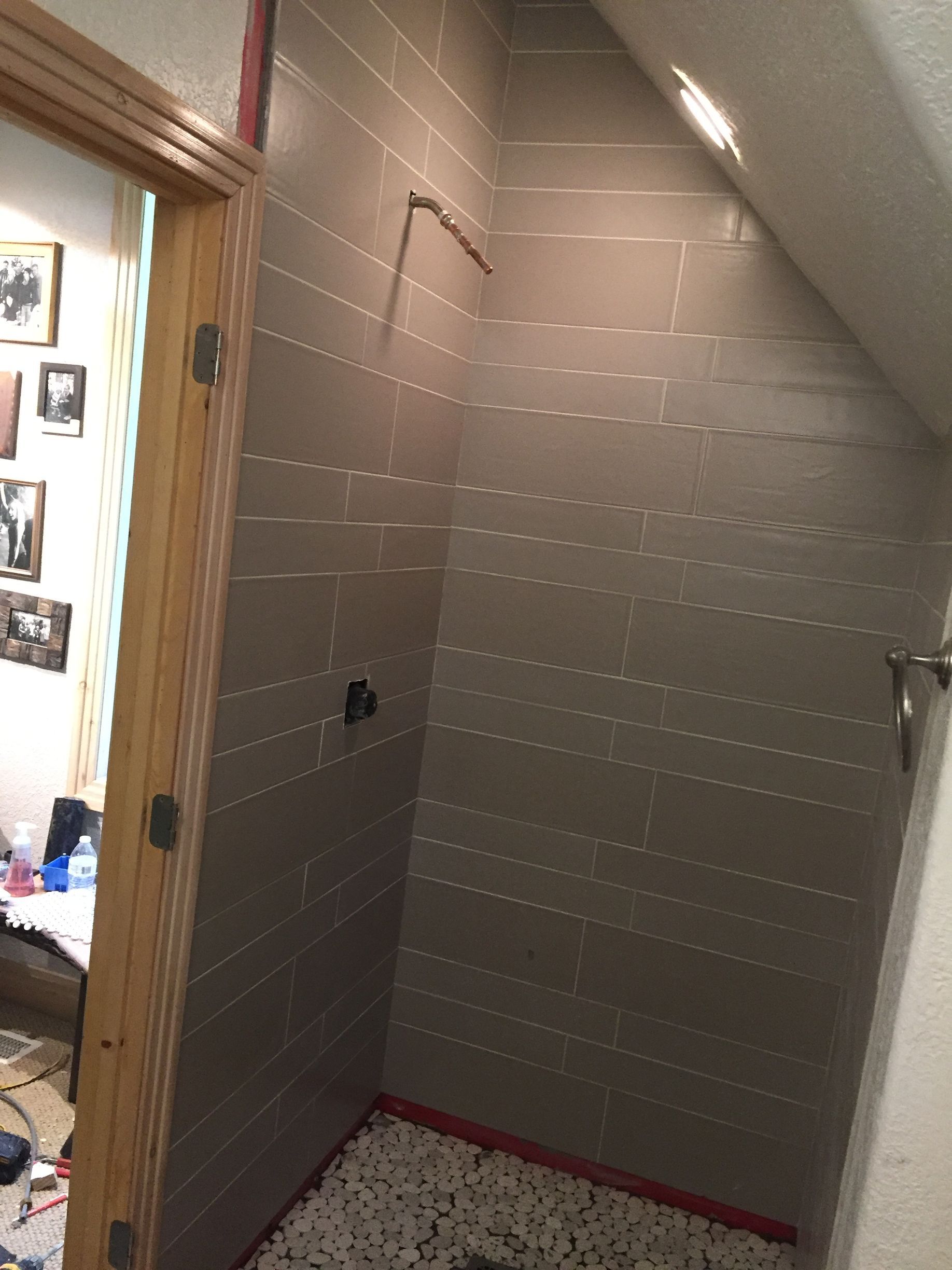 A bathroom with a walk in shower and a wooden door