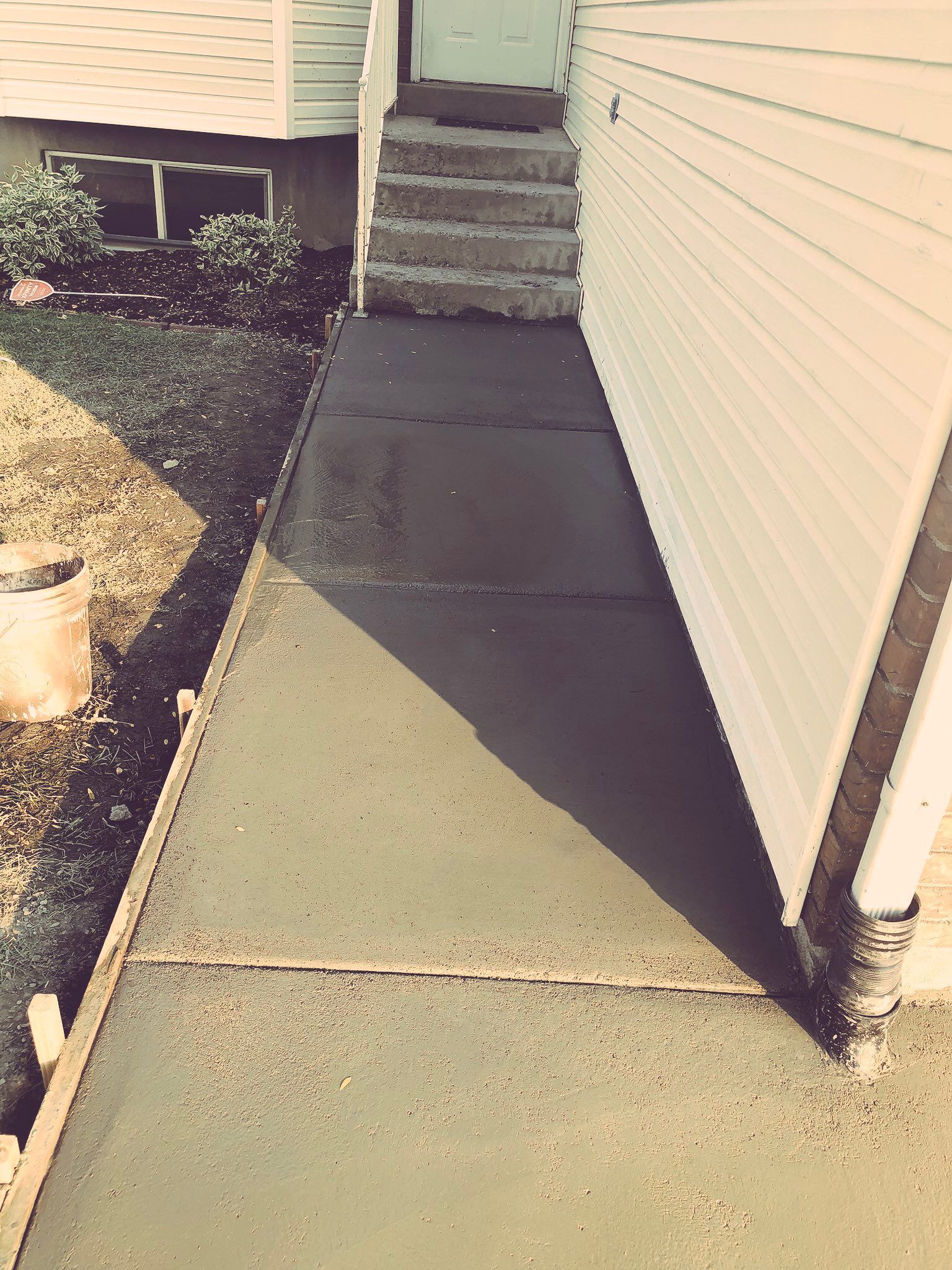 A sidewalk is being built next to a house