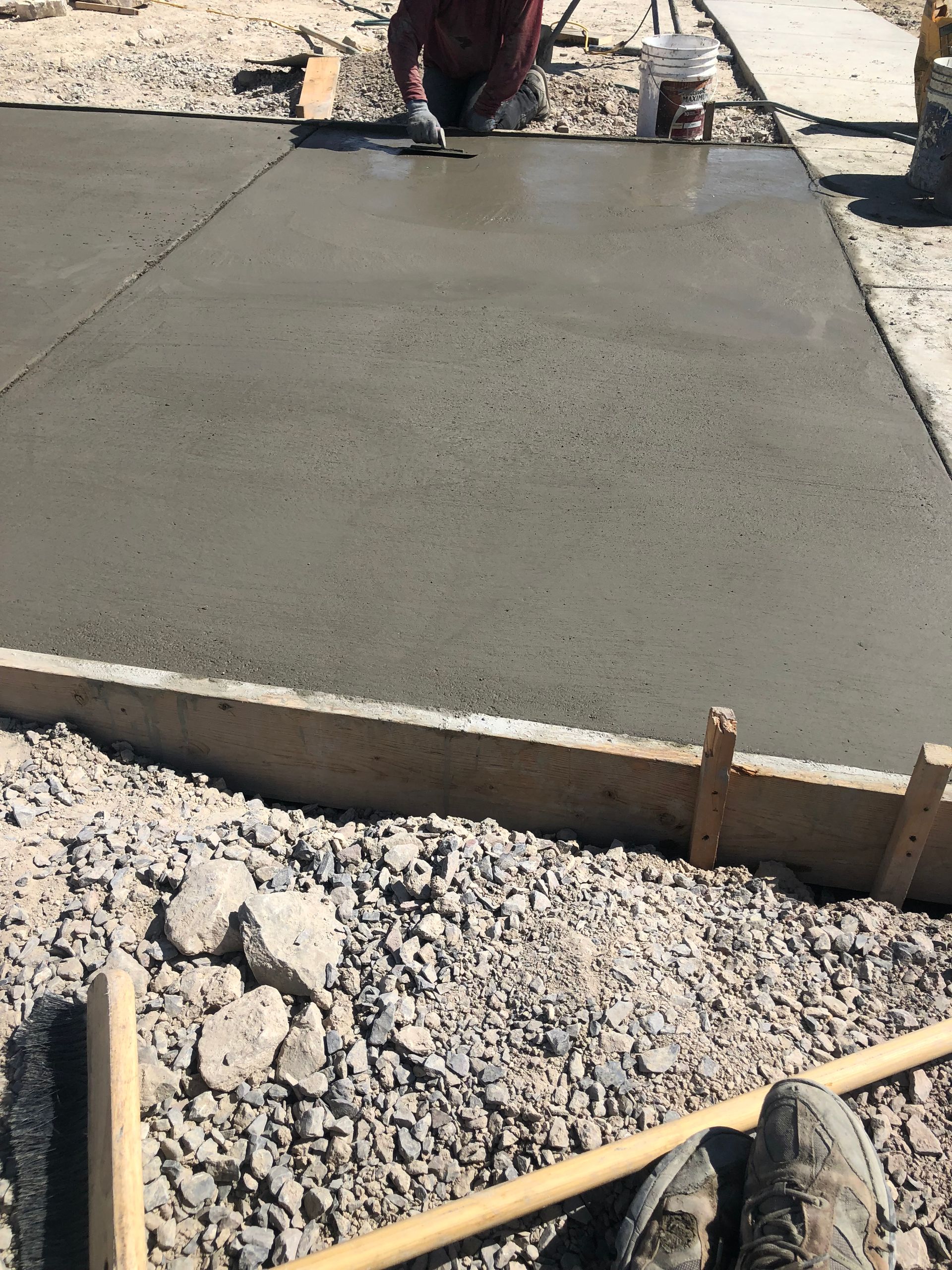A man is working on a concrete surface with a trowel