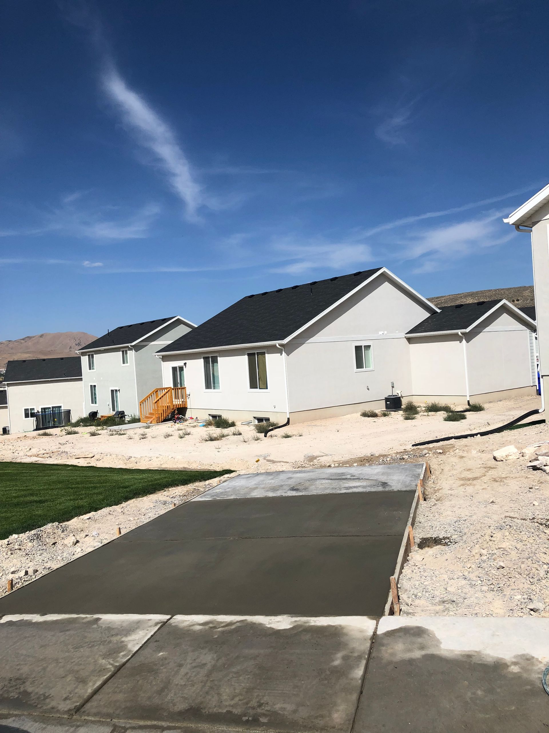 A row of white houses are being built in a residential area.