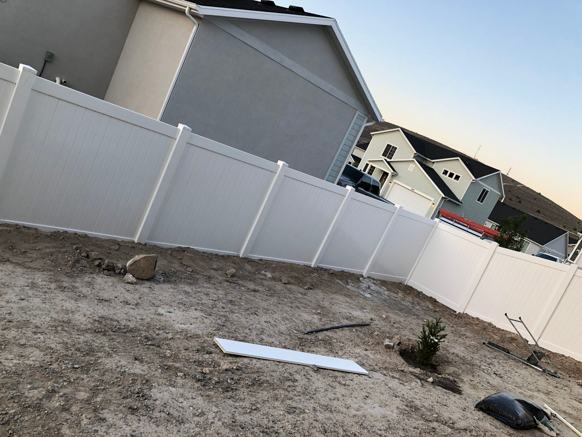 A white fence with a house in the background