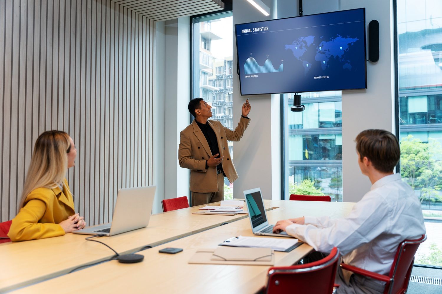 A man is giving a presentation to a group of people in a conference room.