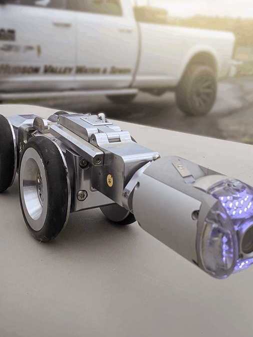 A robot is sitting on a table in front of a truck.