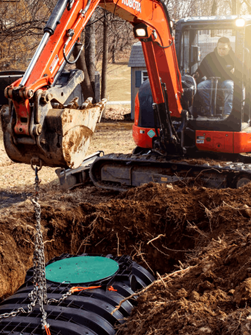 An excavator is digging a hole for a septic tank.