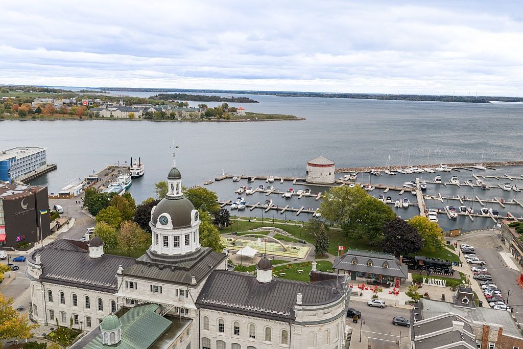 Night view of Kingston City Hall, with lights reflecting on the water.