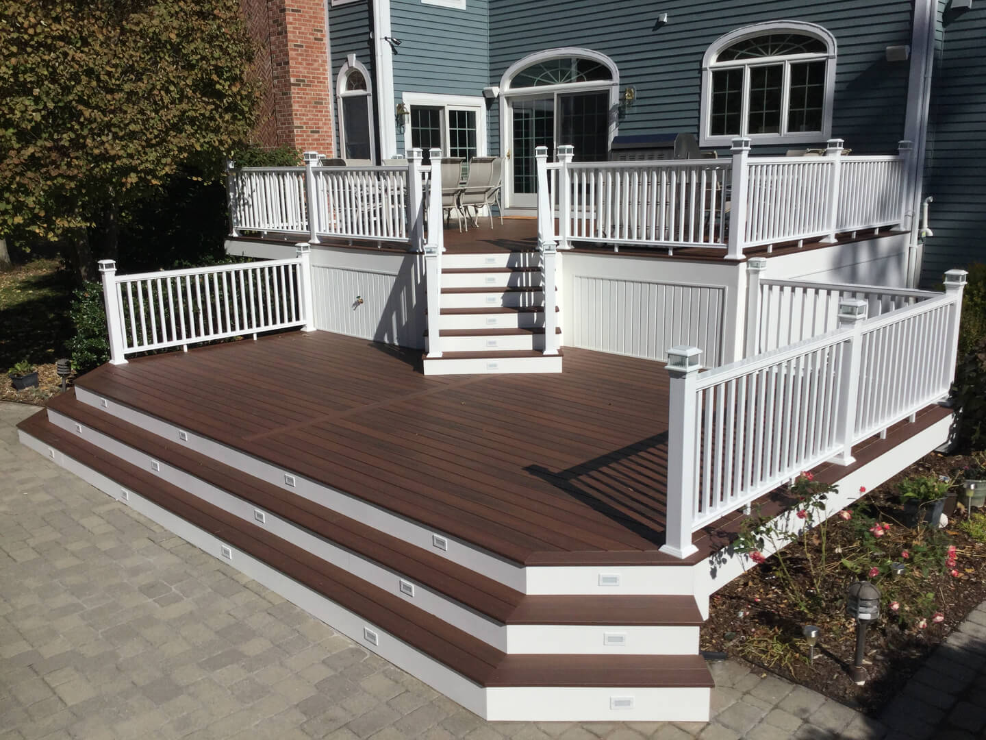 A beautiful deck with a classical wood look, which is built entirely from PVC railing and composite decking products, here in Rochester.