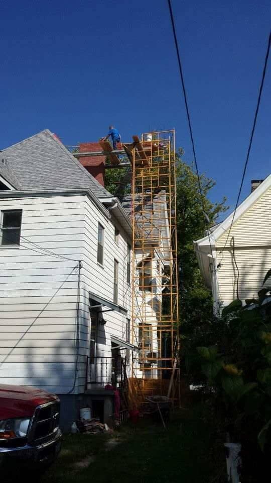 A white house with a red truck parked in front of it.