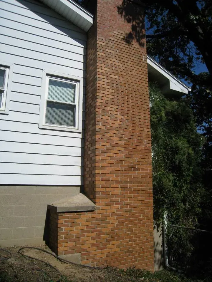 A brick chimney on the side of a house