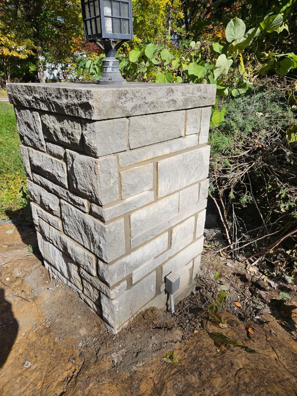 A close up of a brick wall with a metal gutter on it.