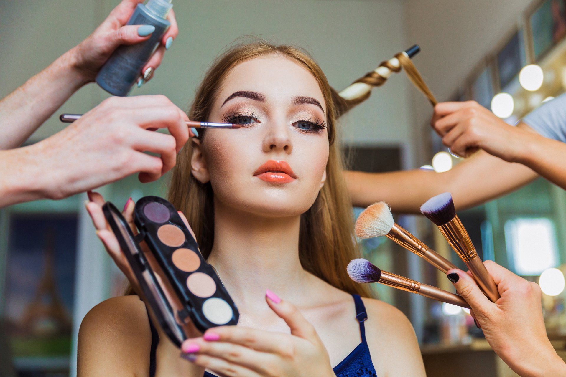 A woman is getting her makeup done in a salon.