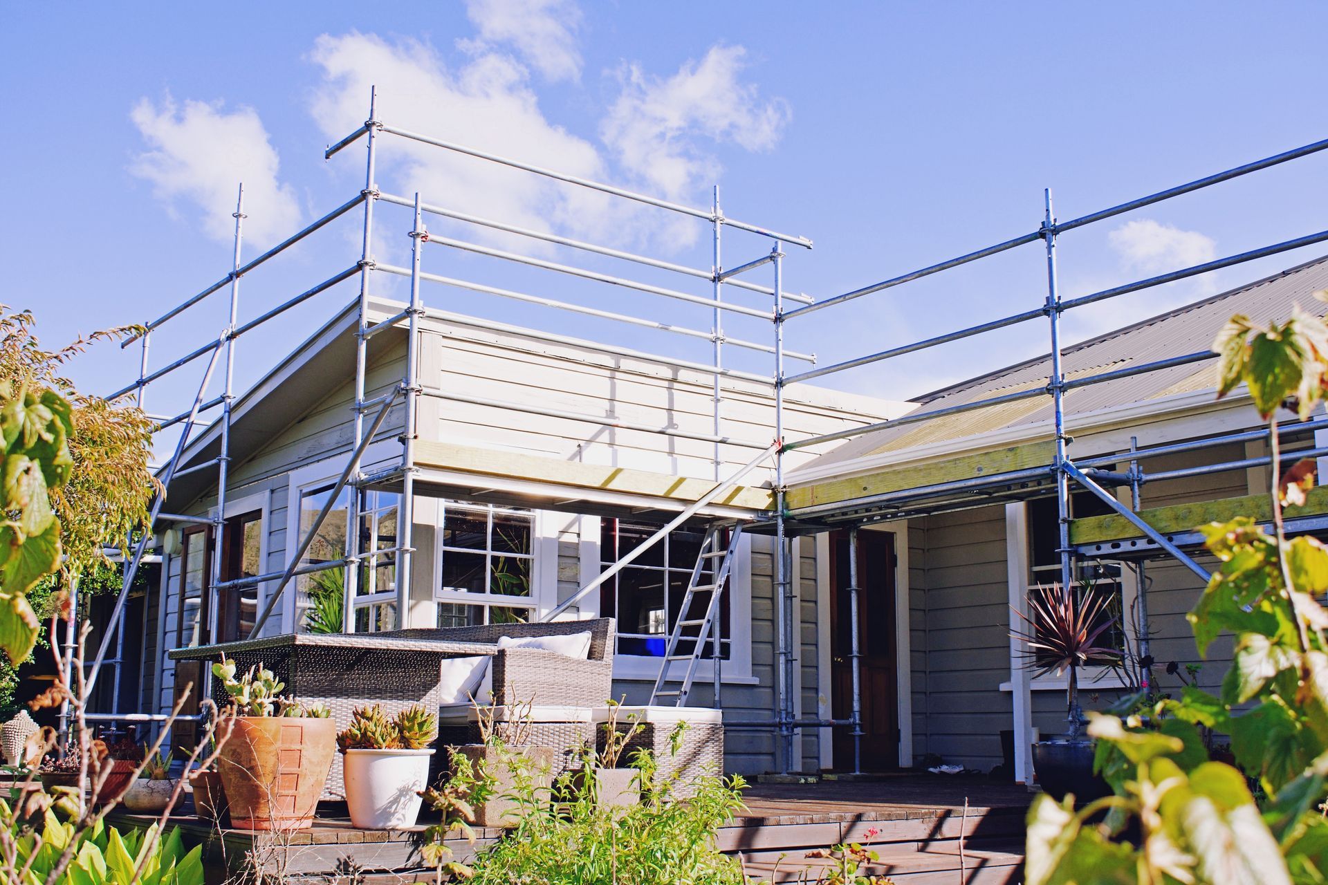 A house is being remodeled with scaffolding on the roof.