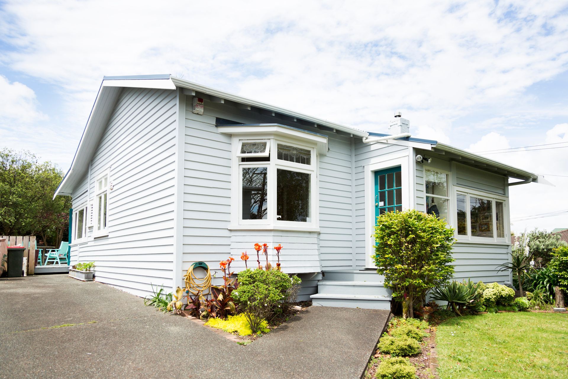 A white house with a lot of windows and a driveway