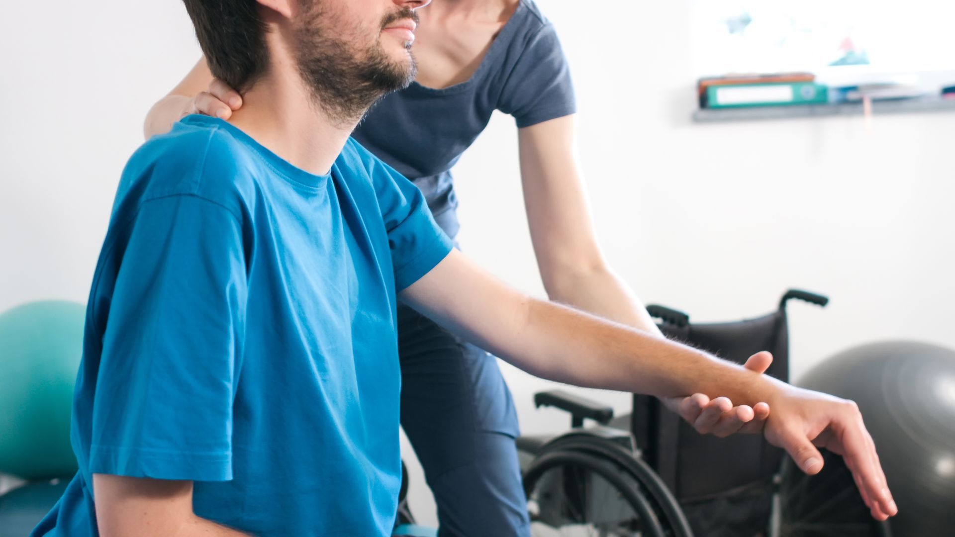 A man in a wheelchair is being helped by a nurse.