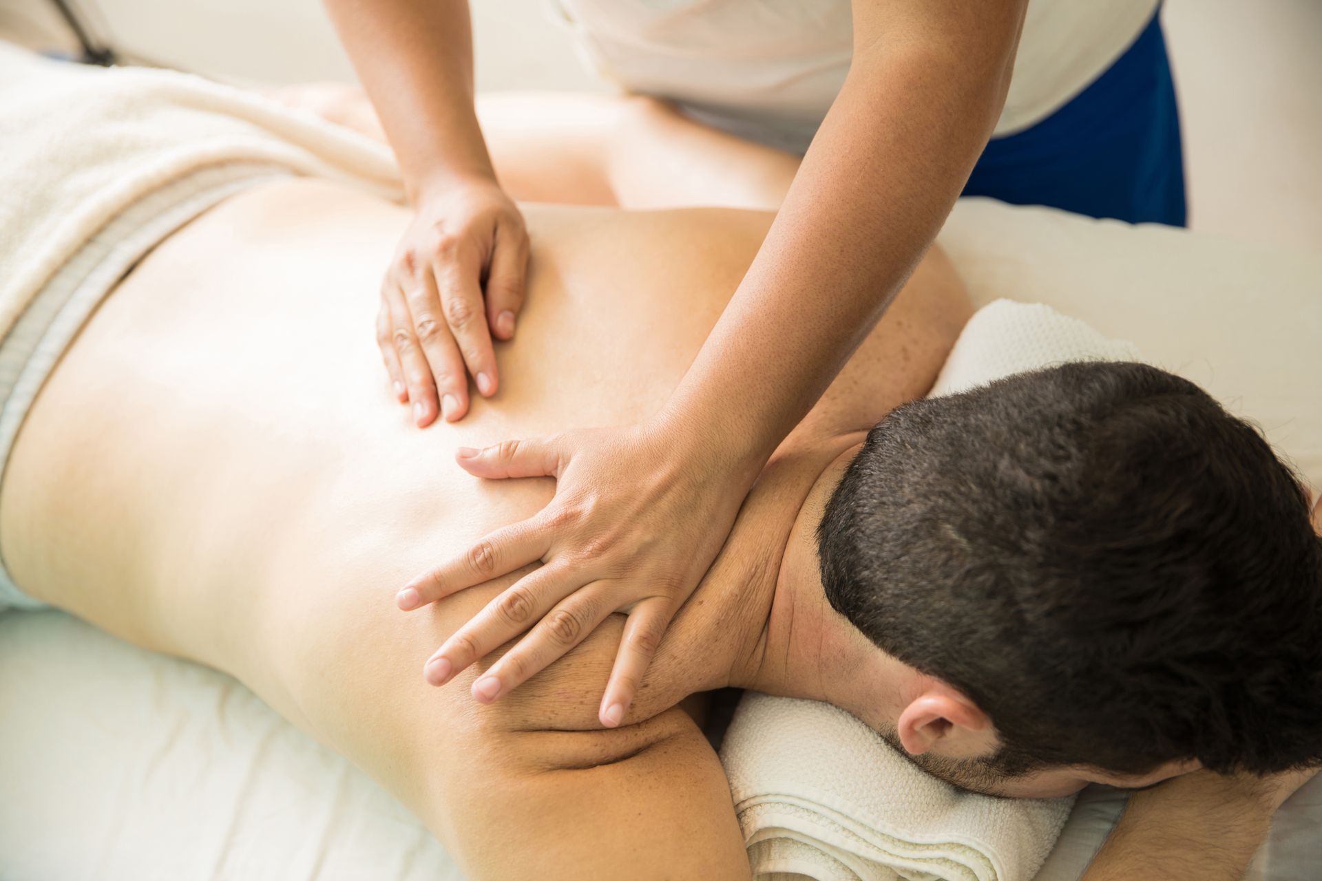 A man is getting a massage from a woman in a spa.