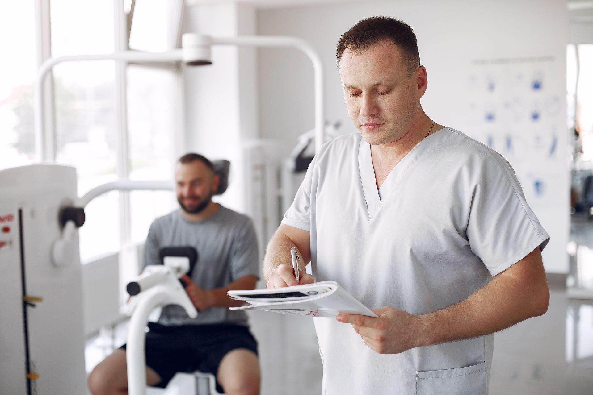 a man is riding a bike while a doctor writes on a clipboard
