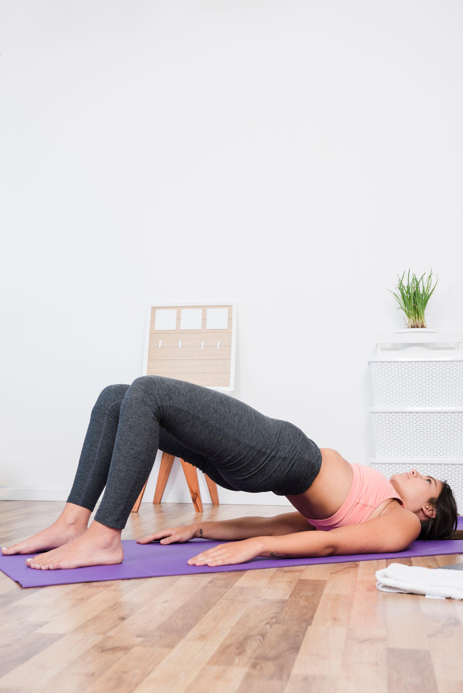 a woman is doing a yoga pose on a purple mat