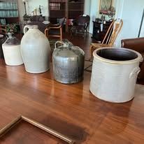 Various ceramic jars and crocks on a wooden table.