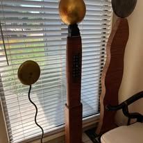Sculptures in front of a window with closed blinds. One has a gold sphere.