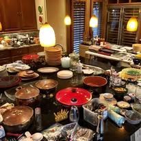A kitchen scene with messy counters, various dishes, and cookware, reflecting a cluttered environment.
